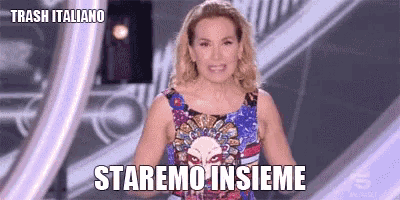 a woman in a colorful dress is standing on a stage with the words staremo insieme written on it .