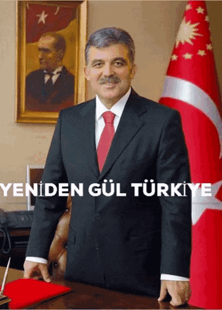a man in a suit and tie stands in front of a flag with the words yeniden gul turkey written below him