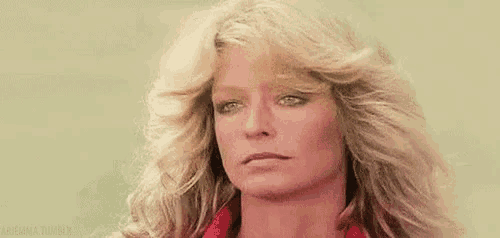 a close up of a woman 's face with blonde hair and blue eyes .