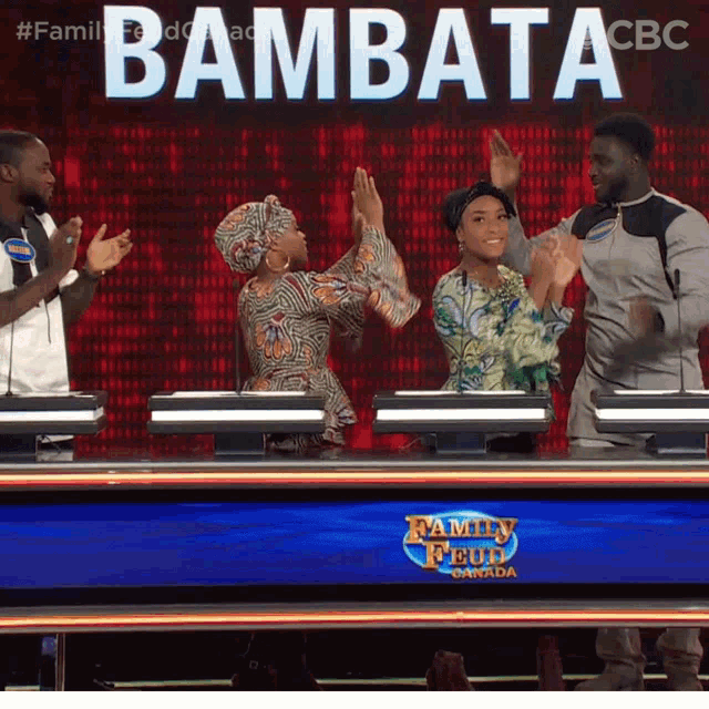 a group of people are standing in front of a family feud board