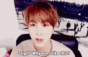 a young man with red hair is sitting in front of a poster that says oh stage