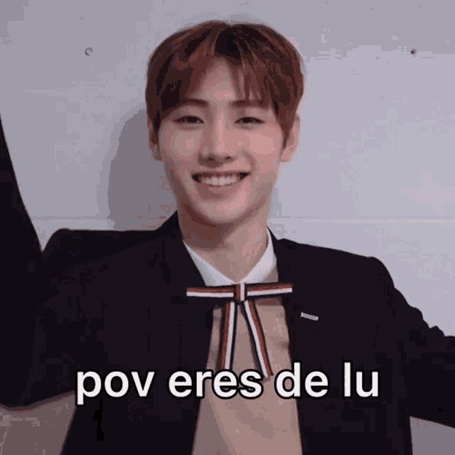 a young man wearing a suit and bow tie is smiling and says pov eres de lu