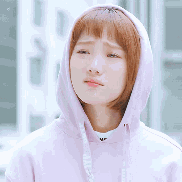a woman wearing a pink hoodie with a white shirt underneath