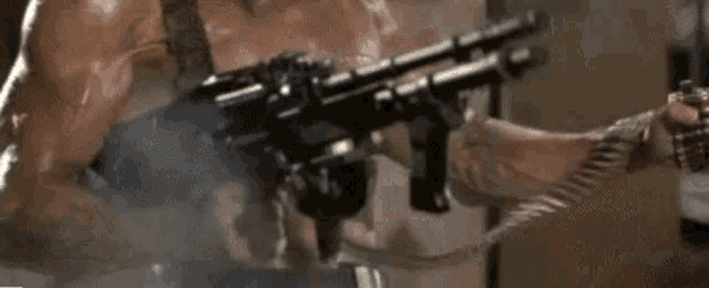 a man is holding a gun with smoke coming out of it in a close up .