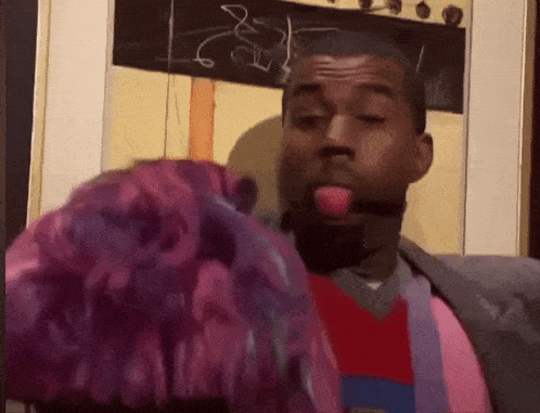 a man with purple hair sticks his tongue out