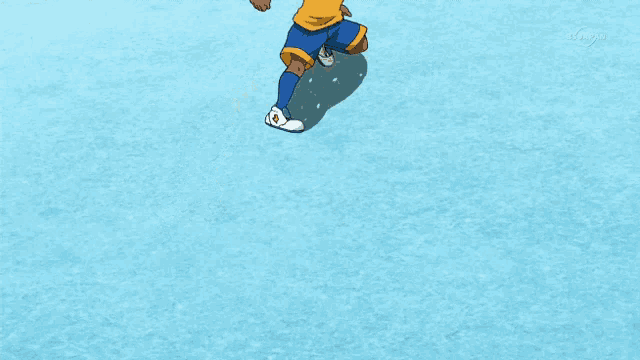 a boy in a yellow and blue uniform is kicking a soccer ball on a blue surface