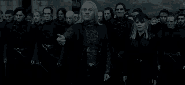 a group of people are standing in a dark room and one man is pointing