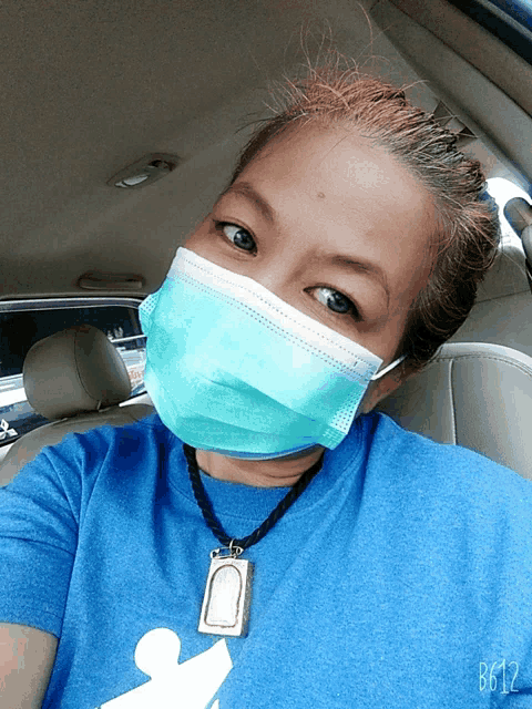 a woman wearing a mask and a blue shirt with the number b612