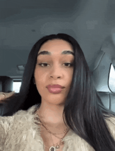 a woman with long black hair is sitting in a car .