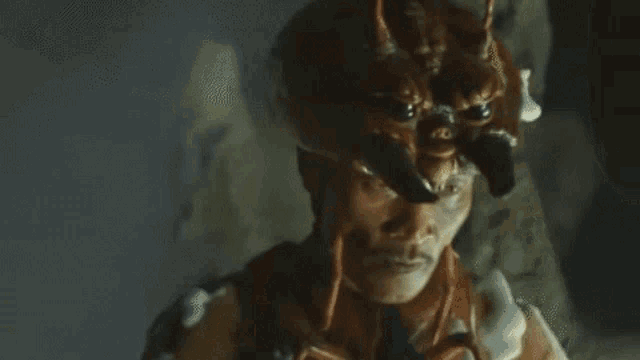 a close up of a man wearing a devil 's hat in the dark .