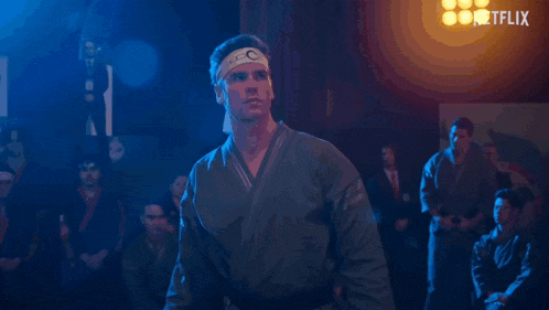 a man in a karate uniform is in front of a netflix sign