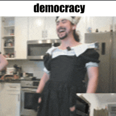 a man dressed as a maid with a crown on his head