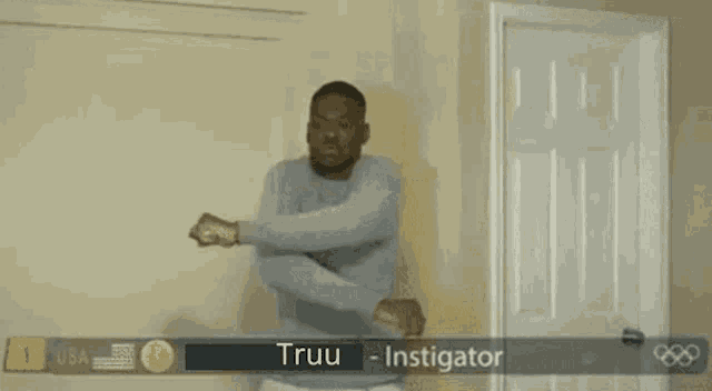 a man is standing in front of a door with the name truu on it .