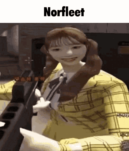 a girl in a yellow plaid shirt is holding a gun in her hand .