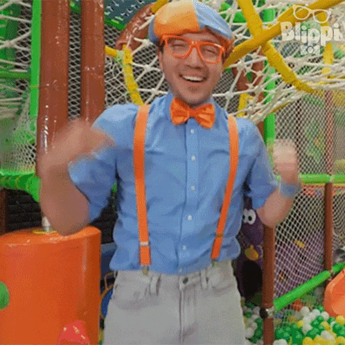 a man in a bow tie and suspenders is standing in a playground .