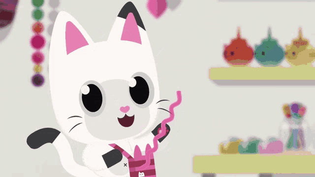 a white cat with pink ears is holding a pink ribbon with the letter x on it