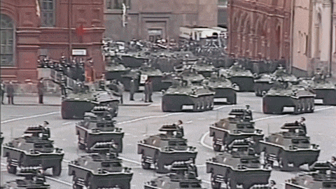 a row of military vehicles are lined up in a parade
