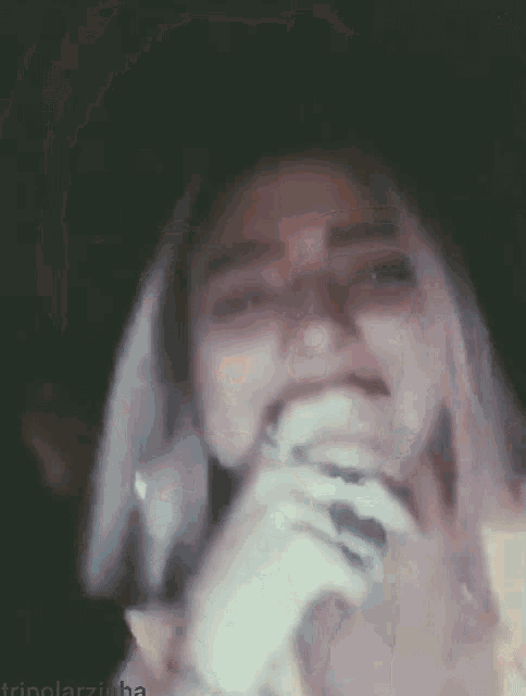 a woman is singing into a microphone in the dark .