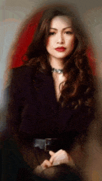 a woman with long brown hair and red lipstick is wearing a black jacket and a black belt