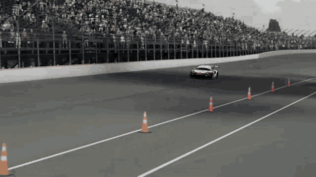 a race car is driving down a track with cones on the side of it