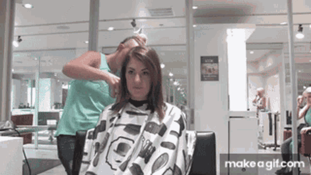 a woman is getting her hair cut by a hairdresser in a salon