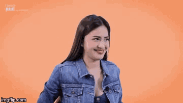 a woman wearing a denim jacket is smiling with imgflip.com in the corner