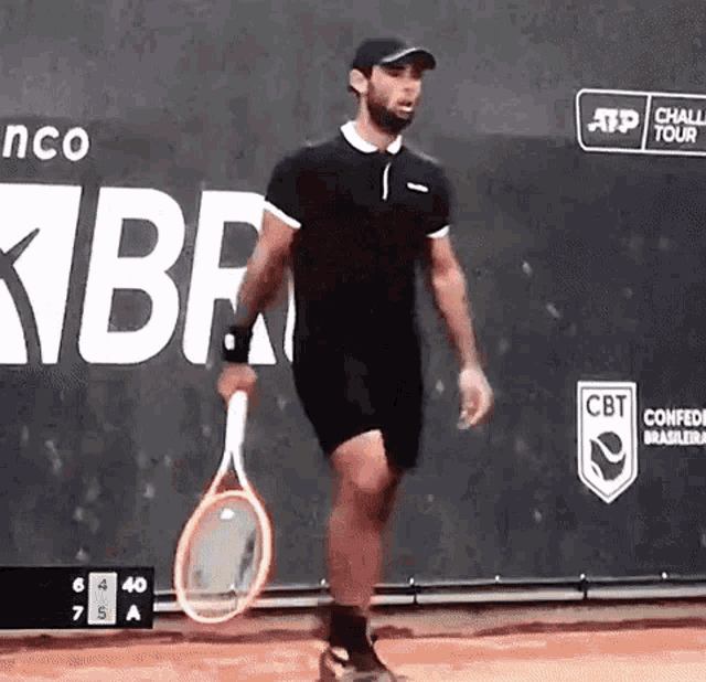 a man is holding a tennis racquet in front of a cbt banner