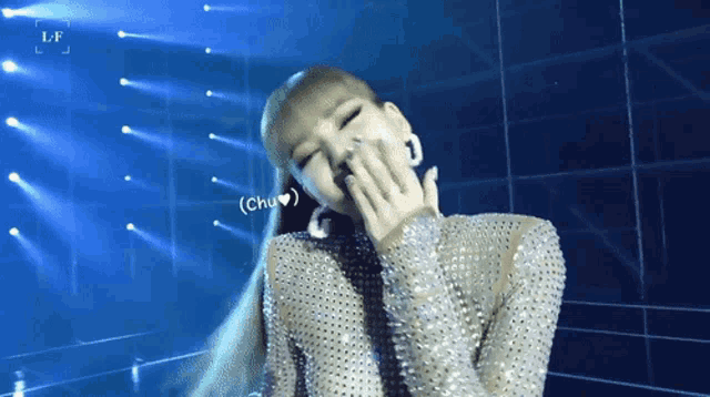 a woman covering her mouth with her hand and the word chu is on the screen behind her
