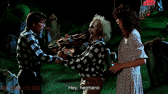 a man in a plaid shirt says hey hermano to another man