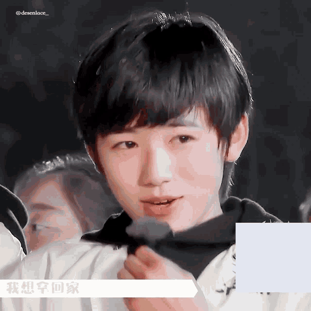 a close up of a young boy 's face with chinese writing on the bottom