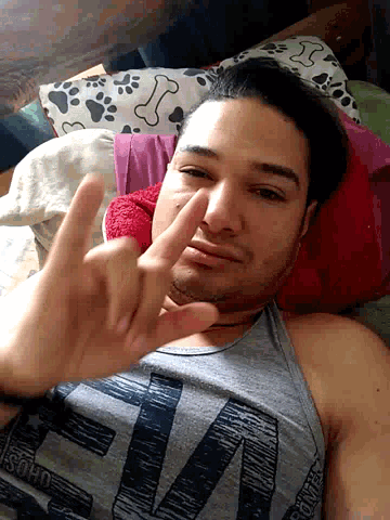 a man laying on a bed with a shirt that says ' psycho ' on it