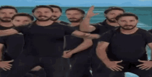 a group of men are standing next to each other on a beach .