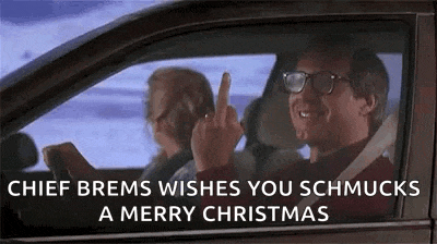 a man is driving a car and giving the middle finger while a woman sits in the back seat .