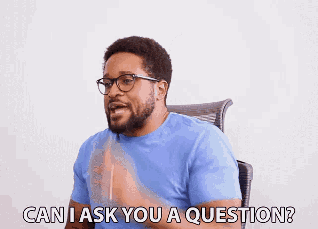 a man with glasses and a blue shirt is asking " can i ask you a question "