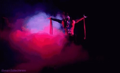 a man is standing in a dark room with his arms outstretched