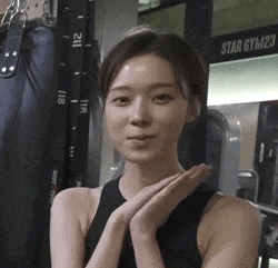 a woman in a black tank top is standing in front of a sign that says star gym