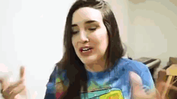 a woman wearing a blue shirt with spongebob on it is making a funny face .