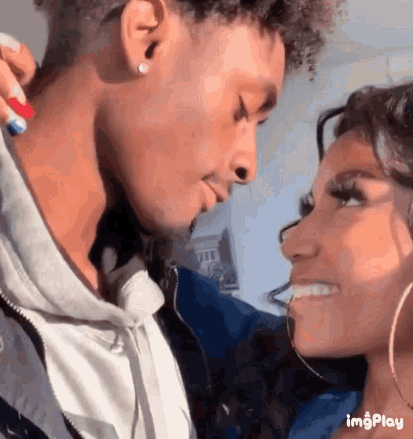 a man and a woman are looking into each other 's eyes and smiling .
