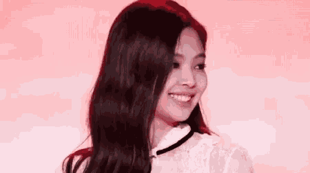a close up of a woman 's face with long black hair and a white shirt .