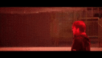a man in a black jacket is holding a gun in his right hand