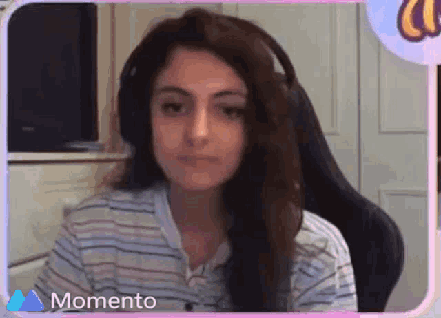 a woman wearing headphones is sitting in a chair in front of a computer screen .