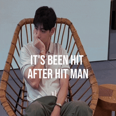 a man sits in a wicker chair with the words " it 's been hit after hit man " above him