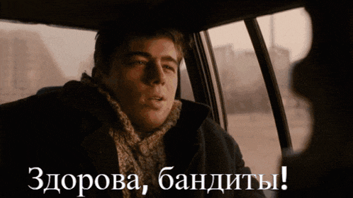 a man sitting in a car with the words " здорова бандиты " written on the bottom