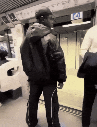 a man in a black jacket is standing in front of a sign that says handicapped