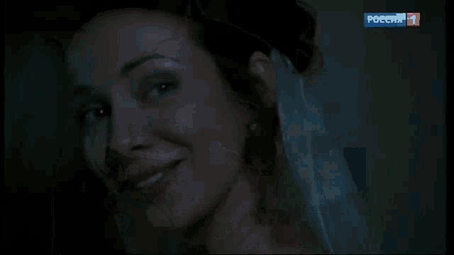 a woman with a flower in her hair is smiling in front of a screen that says " russia 1 "
