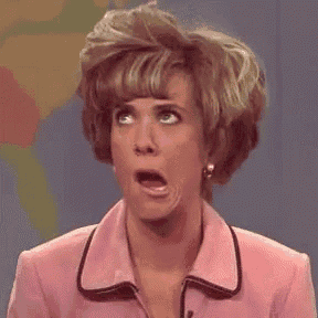 a woman in a pink suit is making a funny face while talking into a microphone .