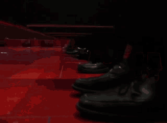 a person is standing in a room with a red floor and a red wall .