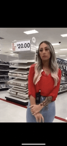 a woman is standing in front of a $ 20.00 sign