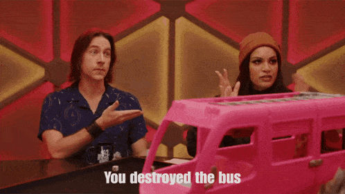 a woman in an elf costume is standing in front of a pink toy bus that says you destroyed the bus