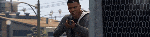 a man holding a gun in front of a building